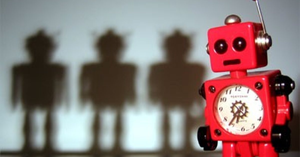 A red toy robot clock casting the shadows of three robots
